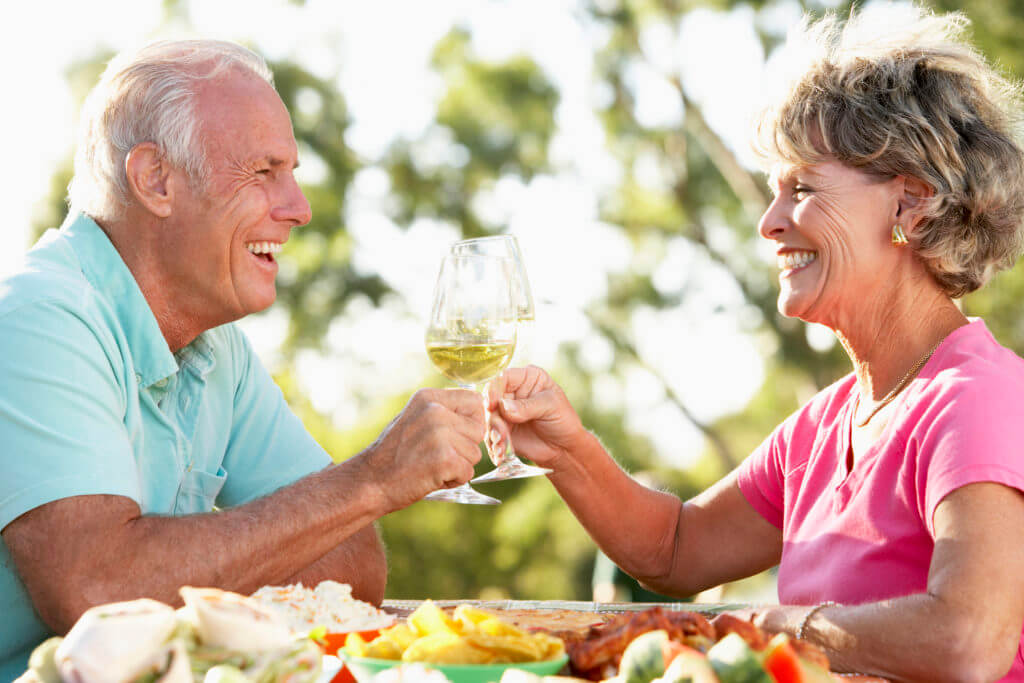 senior couple doing a cheers with wine glasses